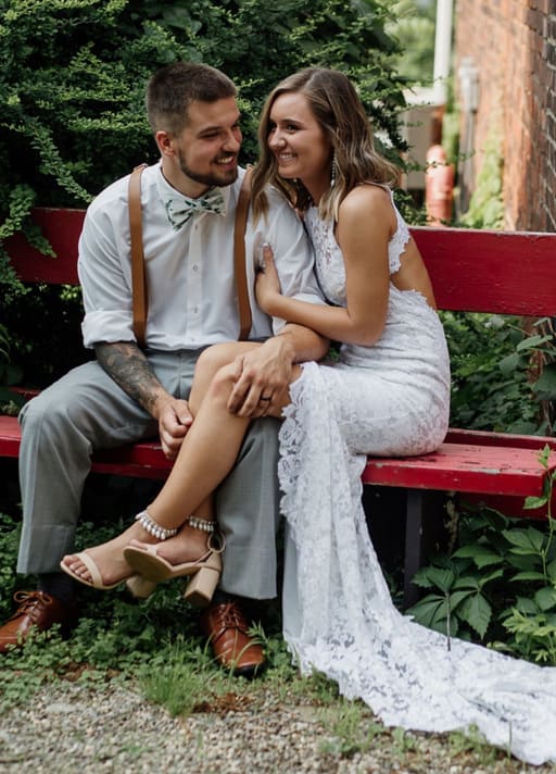 Breanne with Brad sitting on red bench with Khaleesi anklets and heels