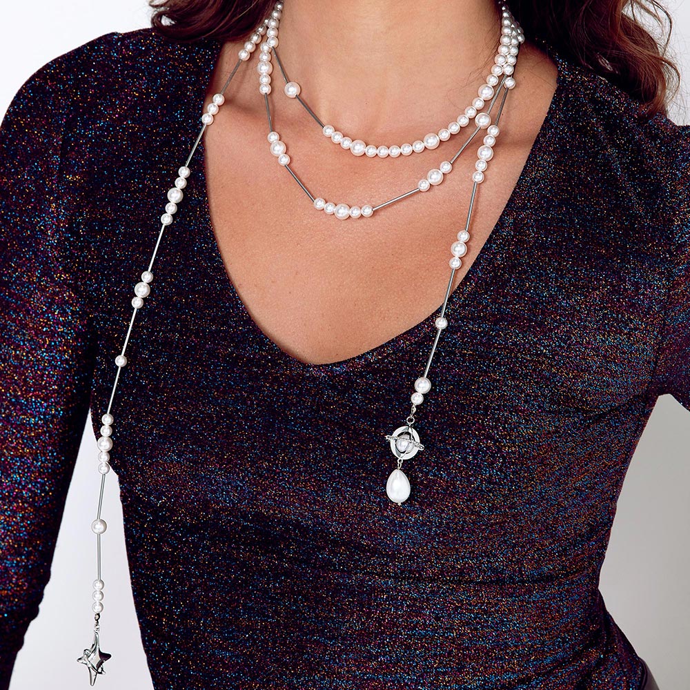 Duchess multi-strand asymmetrical pearl necklace close up worn with dark glitter top.