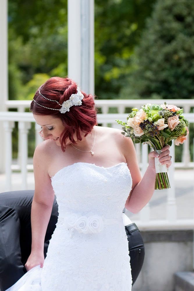 Kristy in white wedding dress holding flower bouquet and wearing custom crystal headpiece