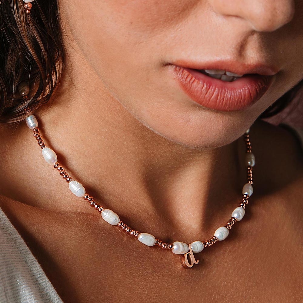 Tarni personalised rose gold and pearl inital necklace with d initial close up looking down.