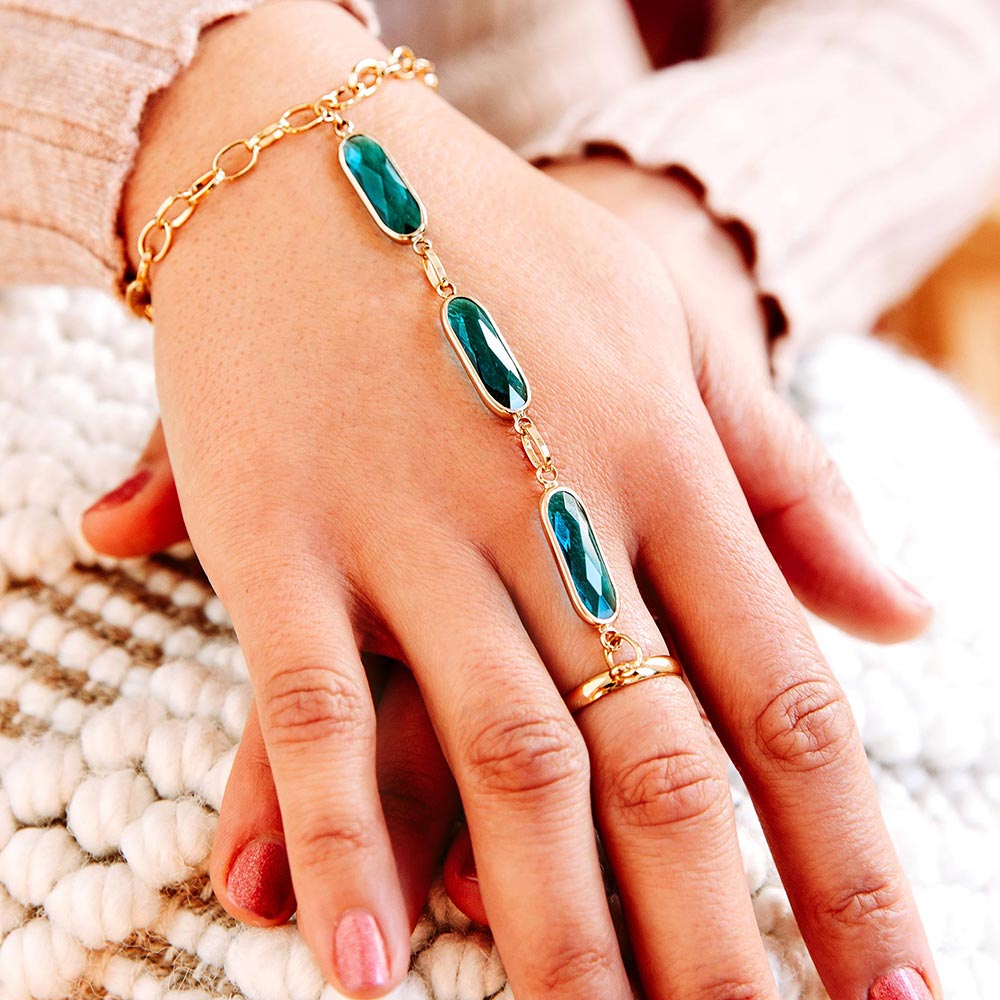Azaria gold bracelet ring chain teal on right hand close up