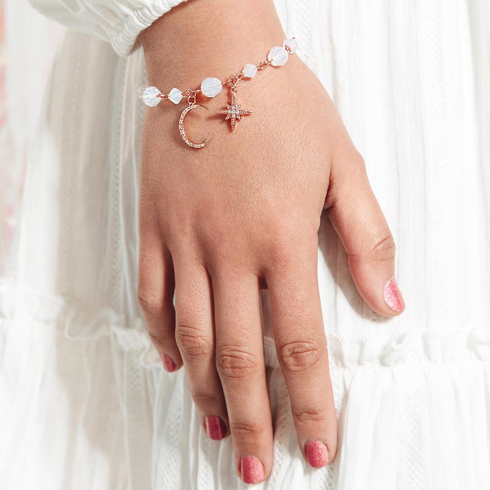 Callista moon and star bracelet on right hand with white dress