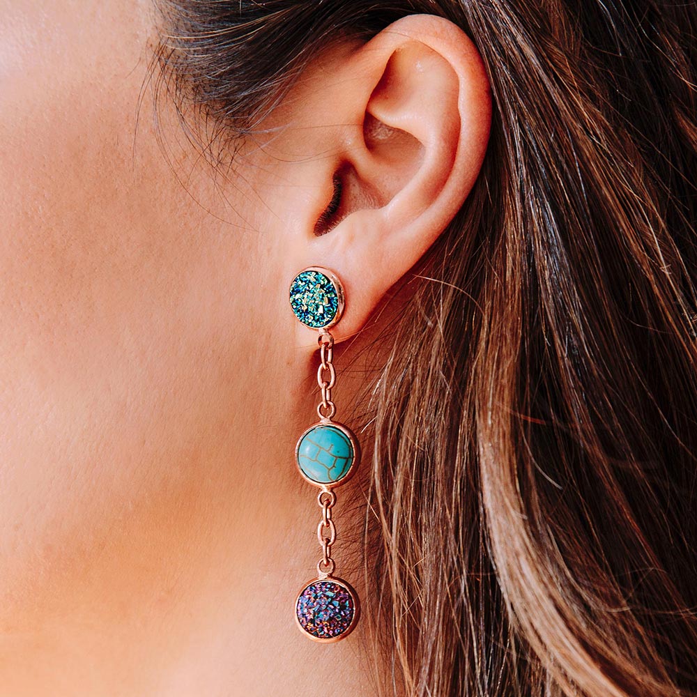 Close up of Jorja druzy dangle earrings rose gold multi-colour stones worn on left ear