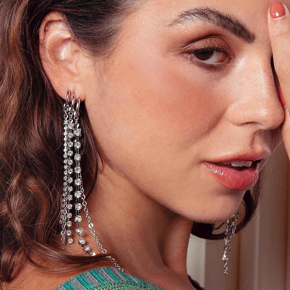 Keisha long rhinestone chain tassel earrings on the right ear.