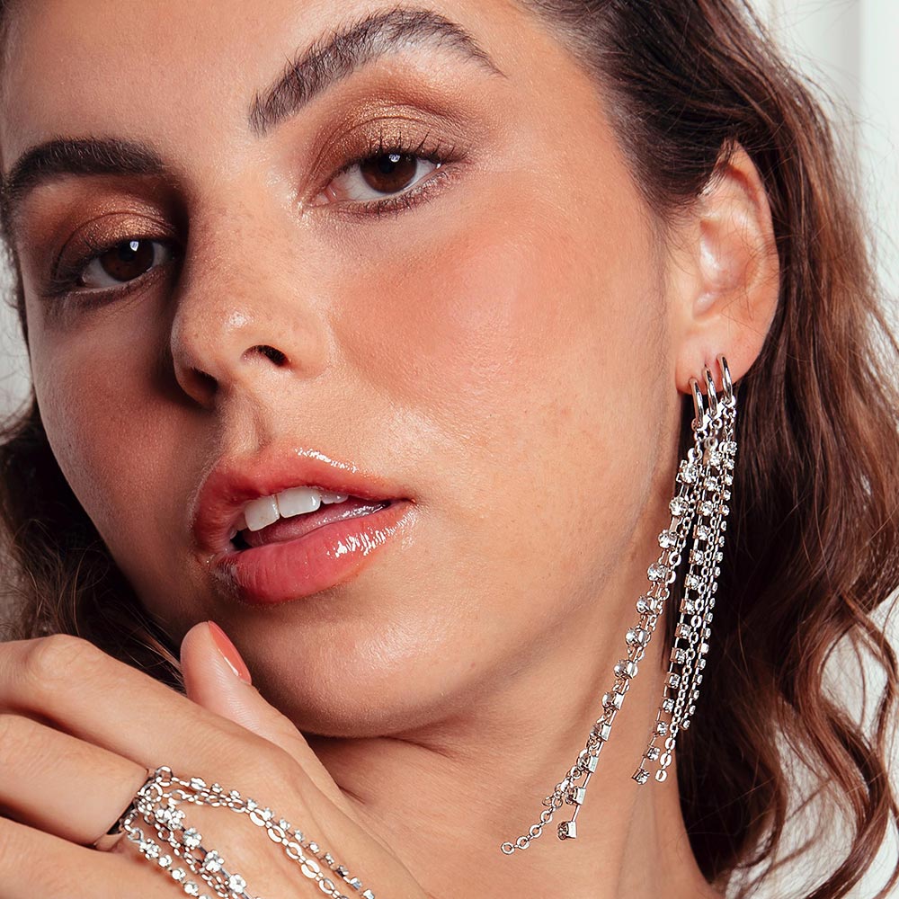 Keisha long rhinestone chain tassel earrings swaying on left side.