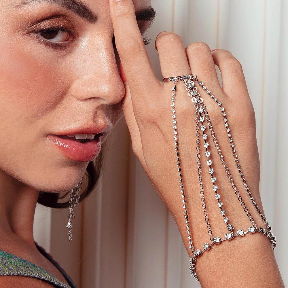 Keisha rhinestone hand chain bracelet on right hand up to nose.