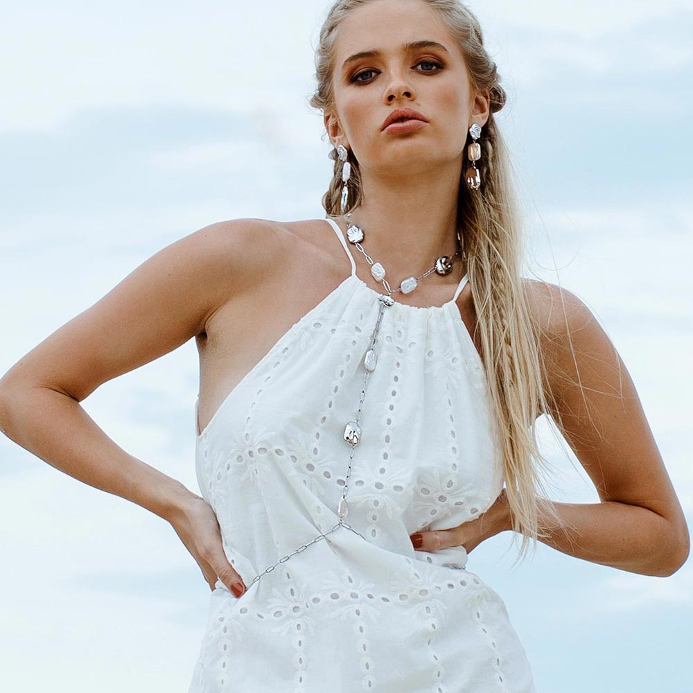 Leora freshwater pearl body chain necklace and earrings worn with white dress.