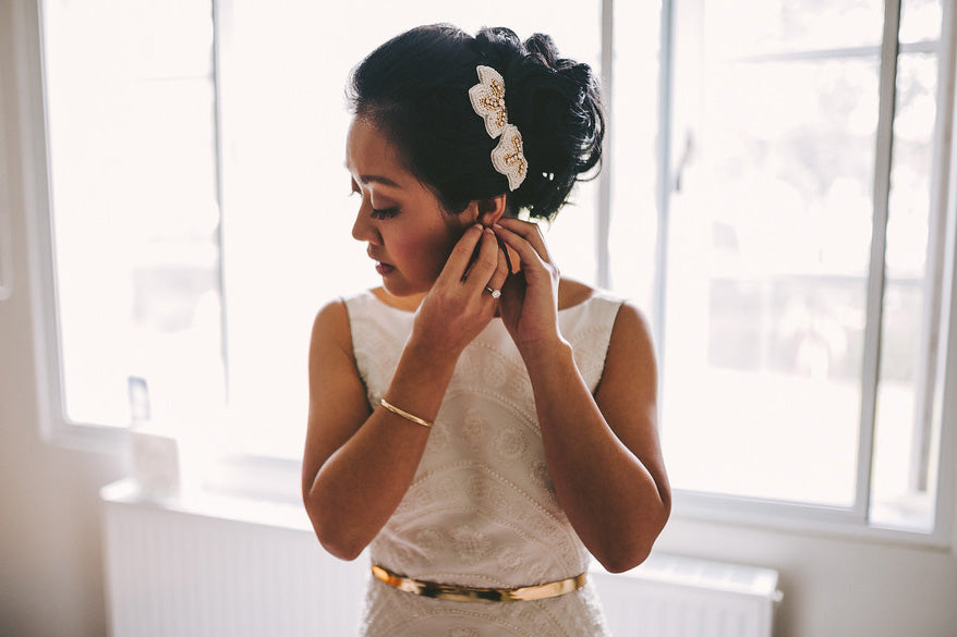 Mealear adjusting earring in white dress and custom headpiece
