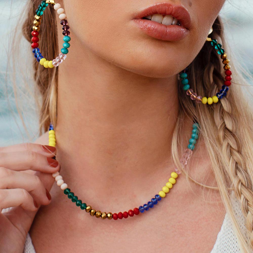 Millie rainbow beaded necklace, right hand holding necklace up.
