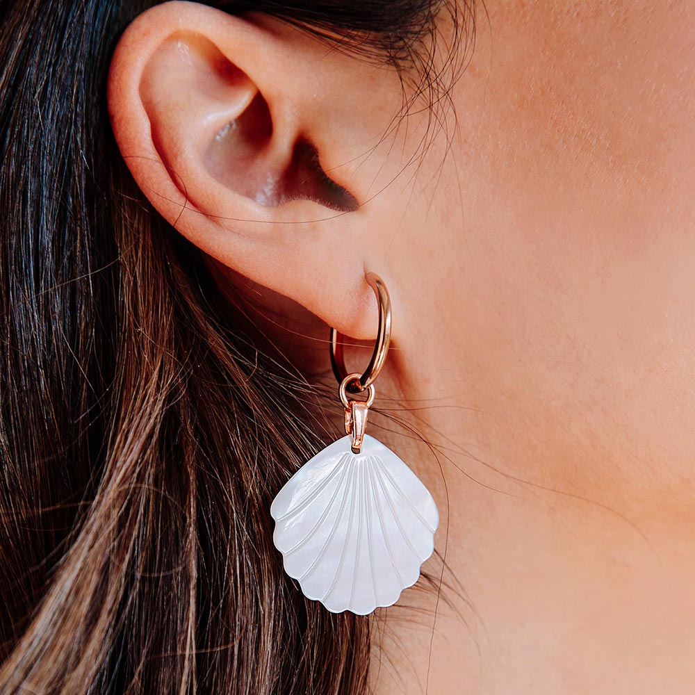 Rue pearl and rose gold earrings set with shell charm close up right ear