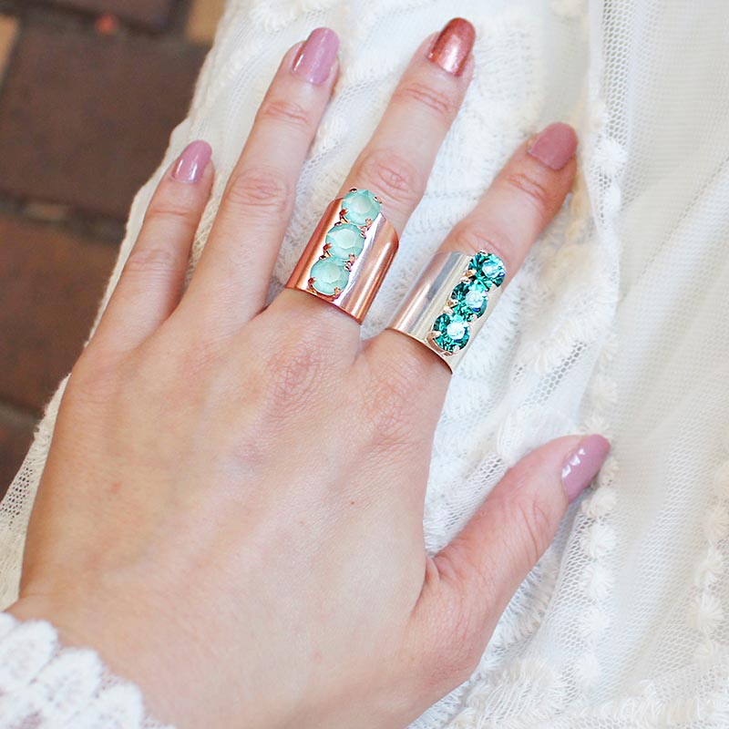 Simone three crystal statement rings mint and blue zircon worn on left hand.
