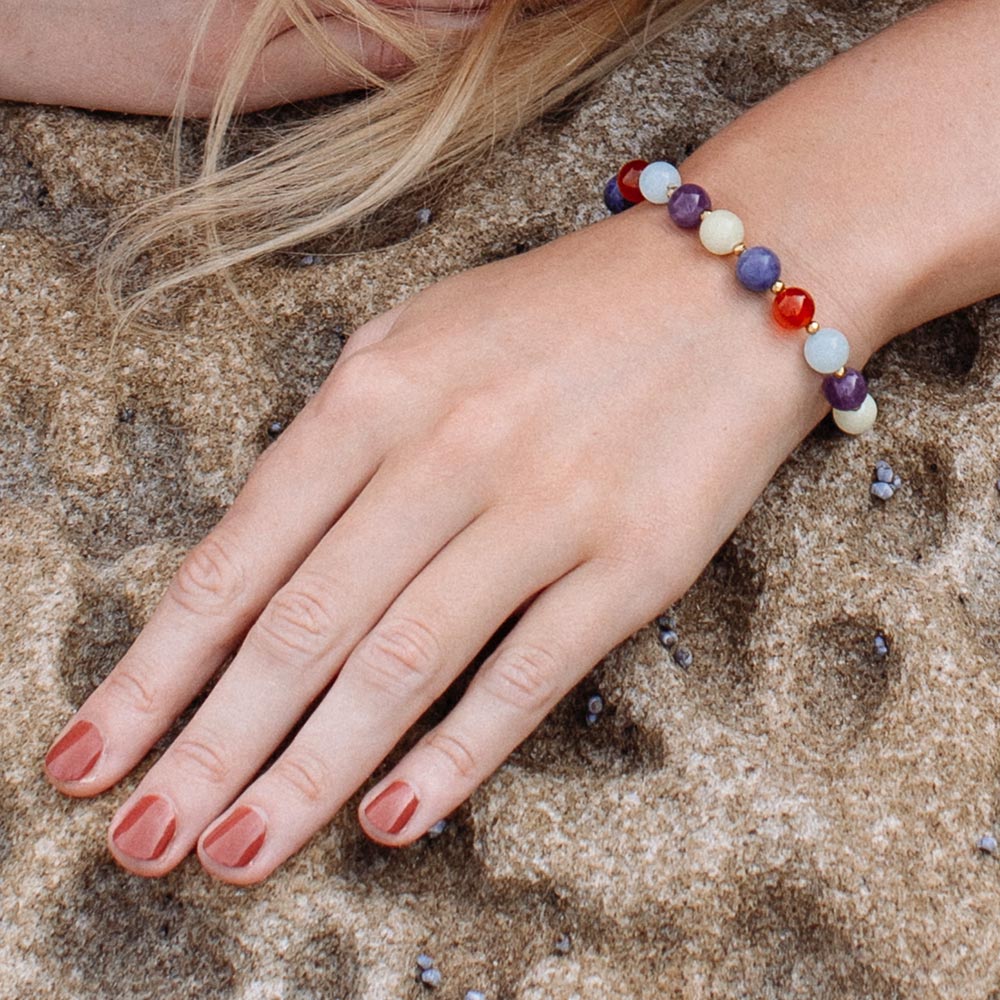 Soleil mixed stone bead bracelet close up left hand on rocks