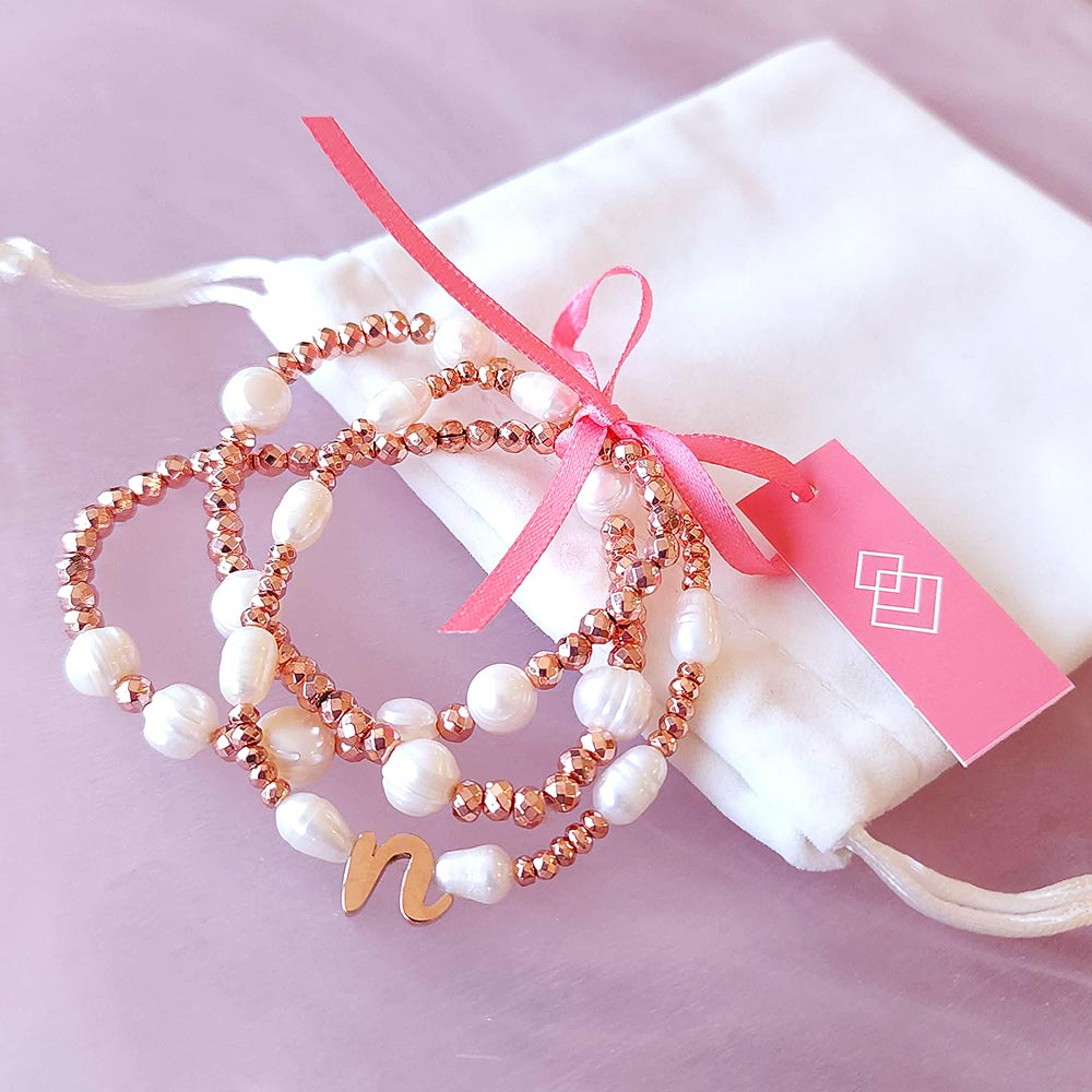 Tarni pearl and rose gold initial bracelet set of three tied with pink ribbon and white velvet pouch