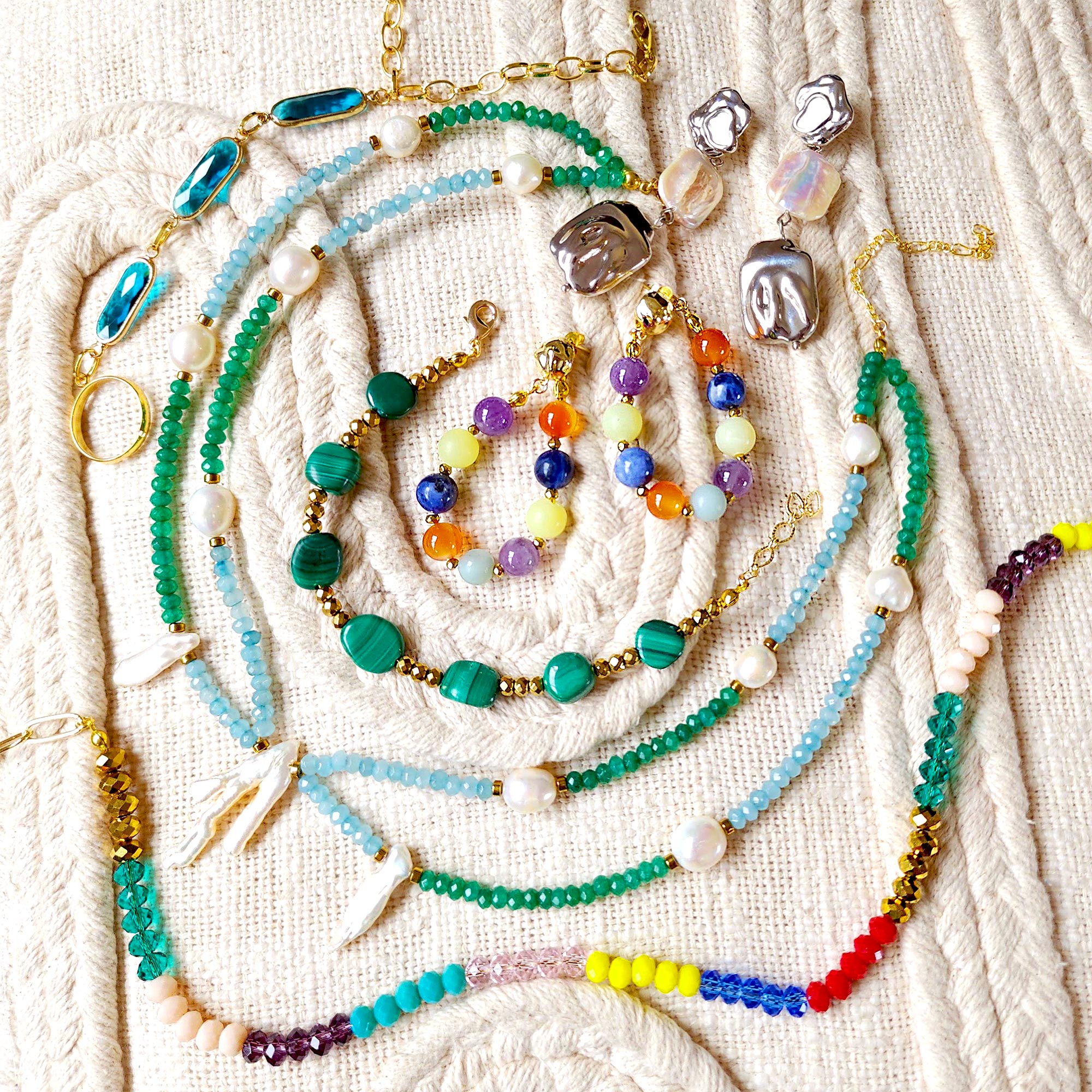 Colorful beaded necklaces on a textured fabric background