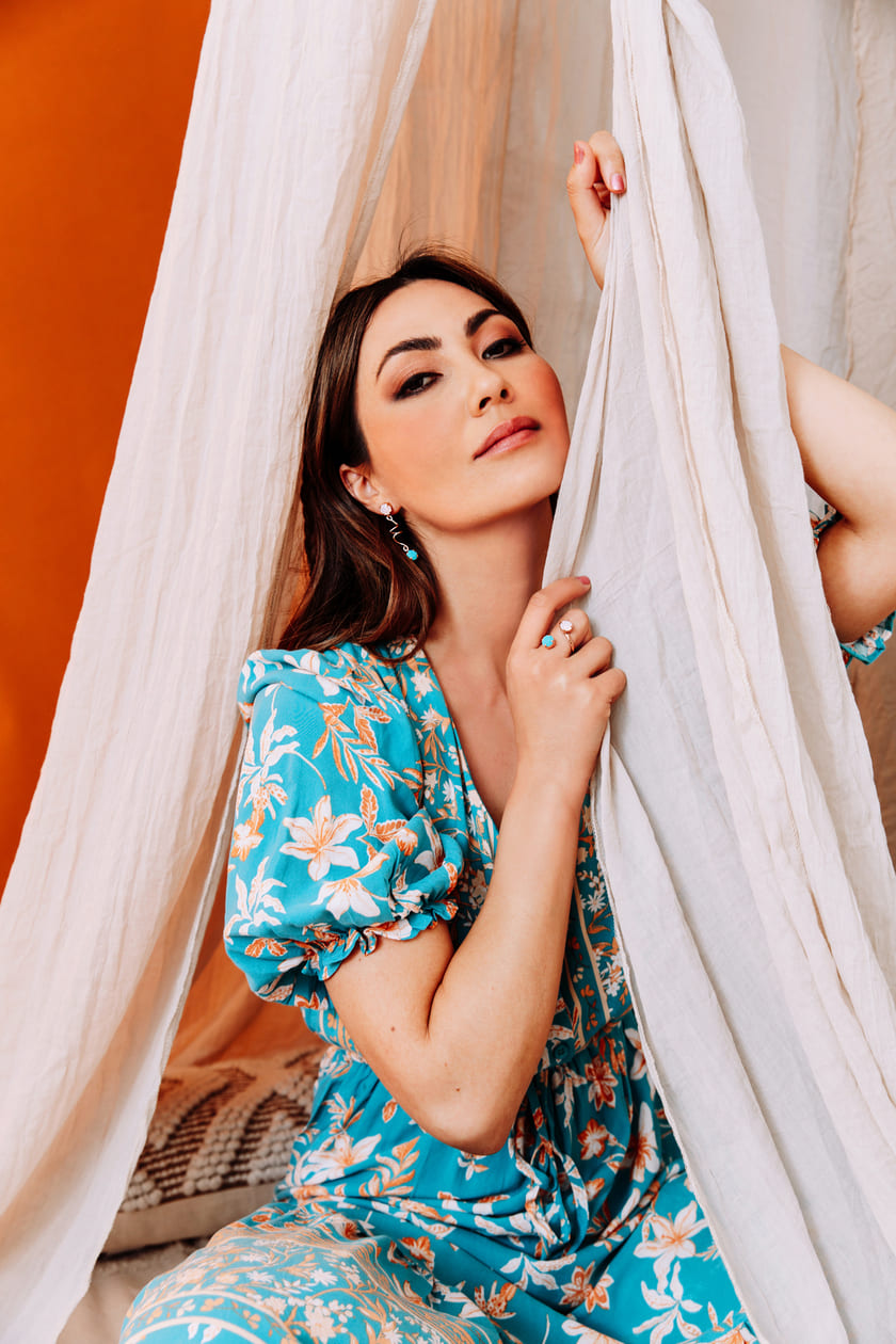 Holding curtain with blue flower dress and Jayda pink turquoise crystal earrings and ring