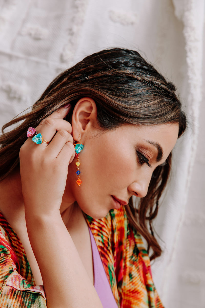 Coloured kaftan wearing Lissa multi colour crystal earring on right ear and rings on right hand