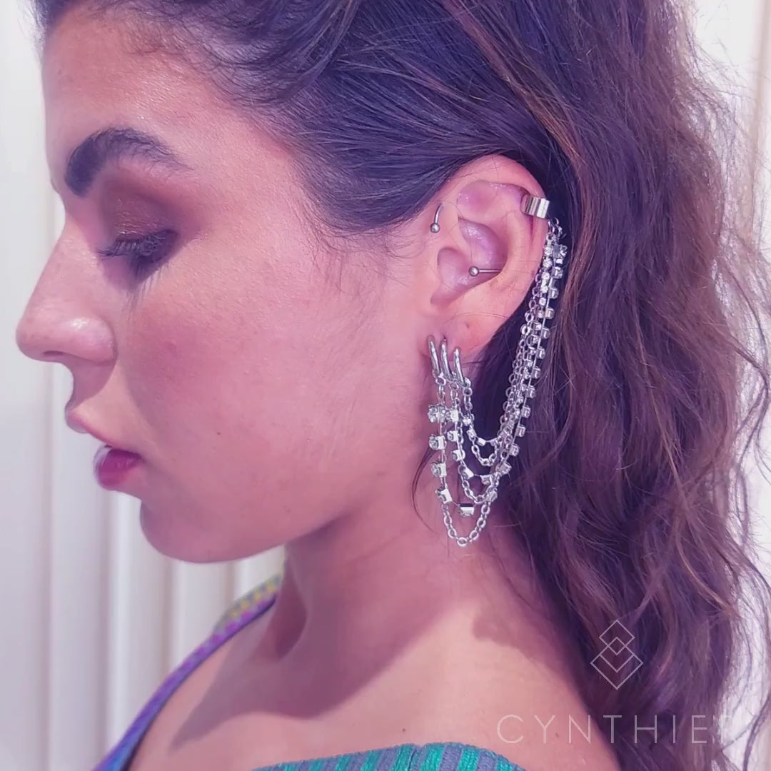 Keisha rhinestone and chain ear cuff earring on right ear, leans head back.
