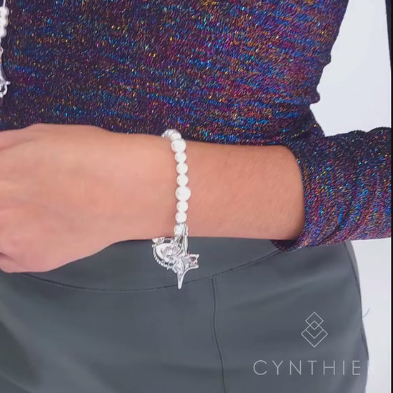 Duchess bracelet worn on left hand, hand goes up to play with necklace.