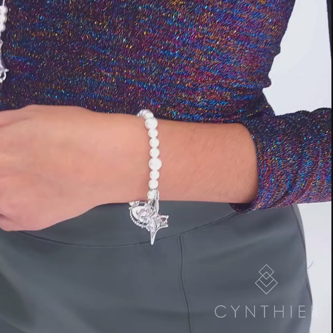 Duchess bracelet worn on left hand, hand goes up to play with necklace.