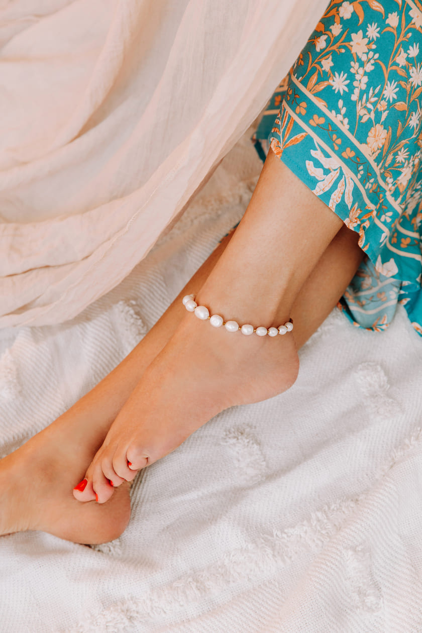 Umiko freshwater pearl gold anklet on left anklet with blue dress