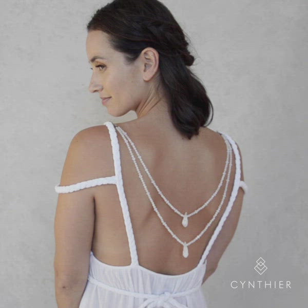 Ecca necklace in white worn at the back. Simple hook clasps onto dress straps.