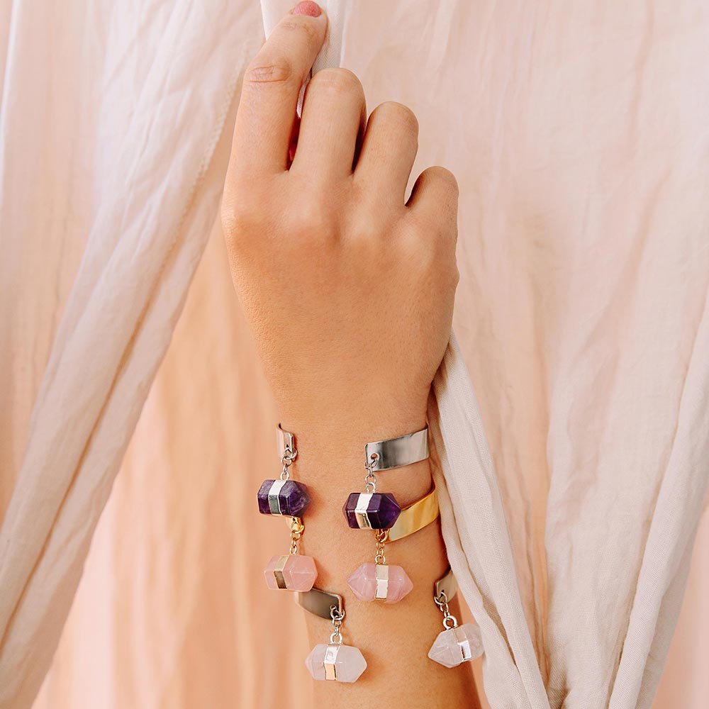 Chakra hexagon stone cuff bracelet in crystal quartz, rose quartz and amethyst worn on hand up holding curtain