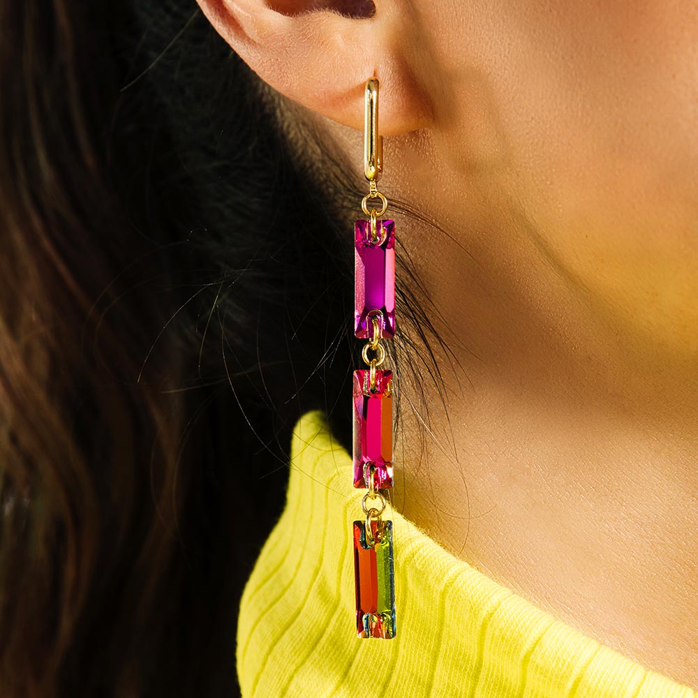 Dylan long rectangle crystal earrings rainbow and gold, close up on right ear