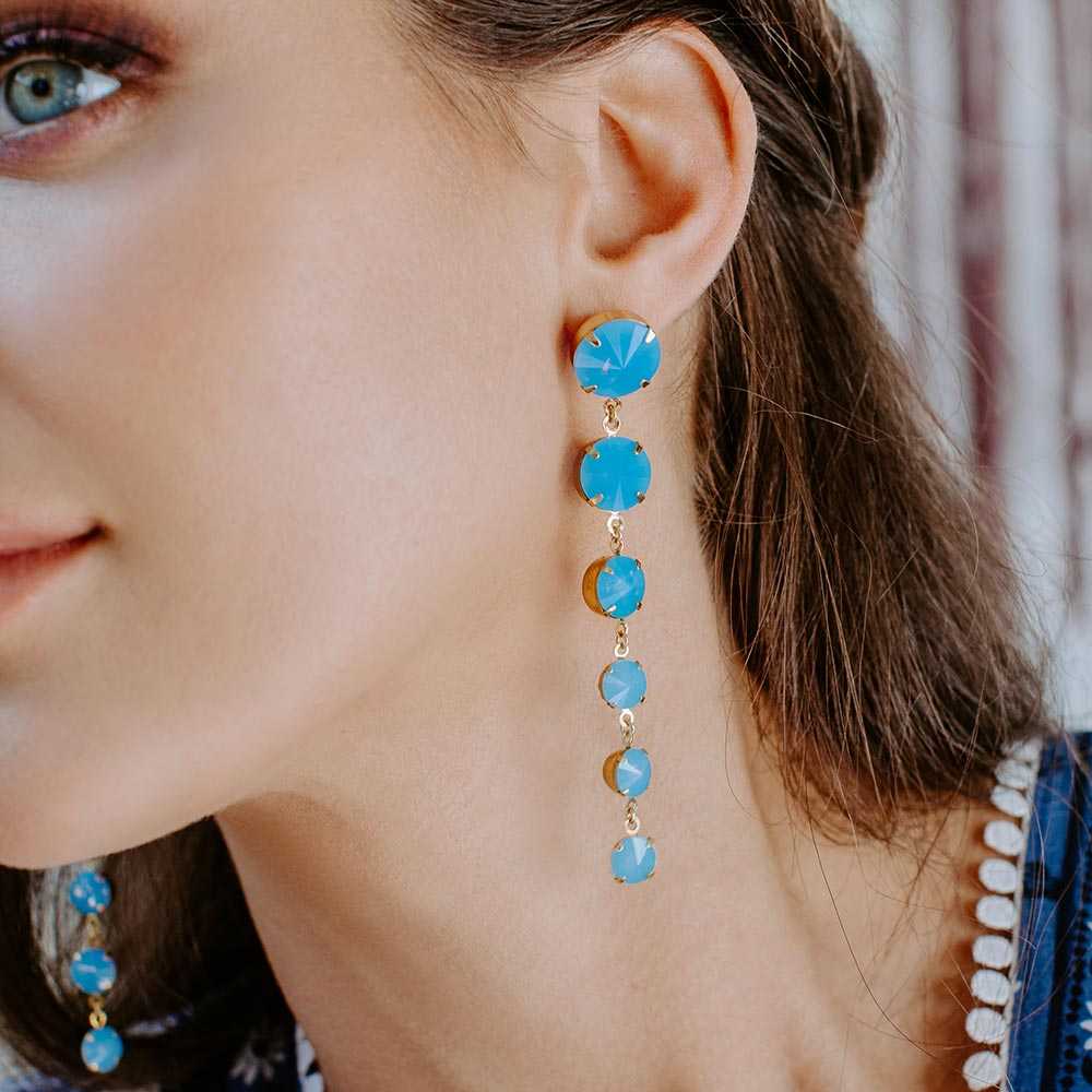 Kelsey Crystal Drop Earrings in Blue, close up on left ear