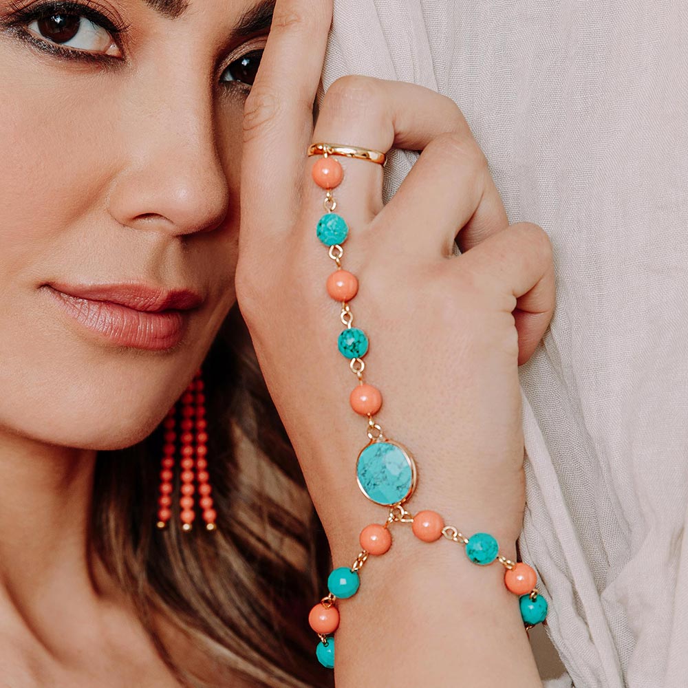 Tinashe turquoise and coral bracelet ring right hand holding curtain