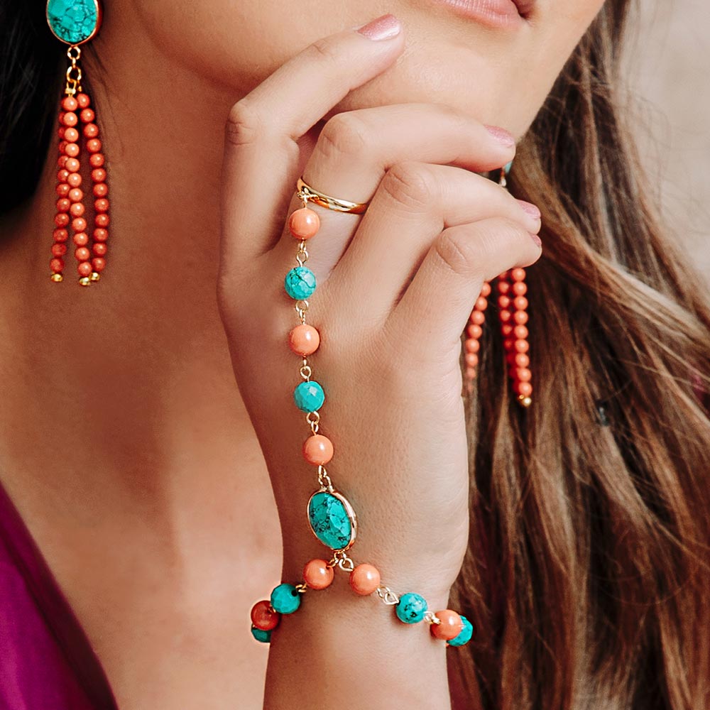 Tinashe turquoise and coral bracelet ring on right hand under chin