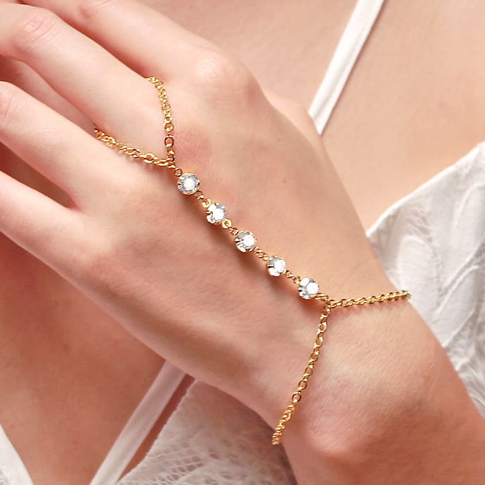 Alek crystal hand chain bracelet in gold on left hand
