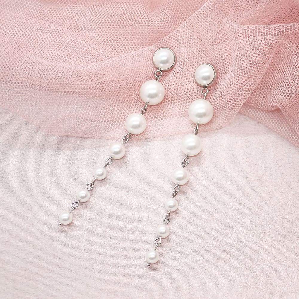 Silver Caiti modern pearl drop earrings on pink