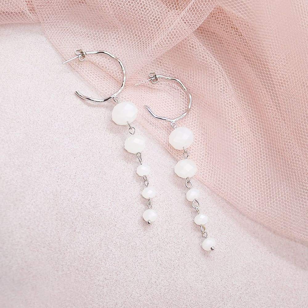 White Kelana Dangle Bead Earrings on pink
