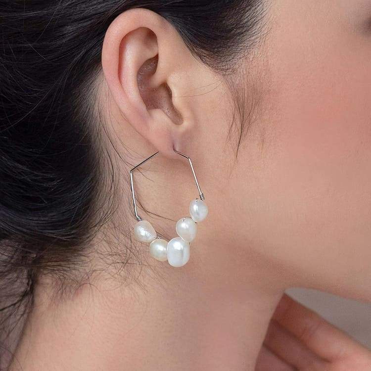 Kygo freshwater pearl geo earrings on right ear