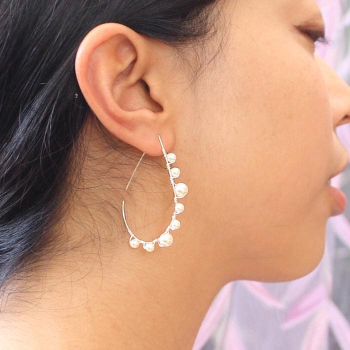 Lulu pearl teardrop hoop earrings silver with off white pearls on right ear