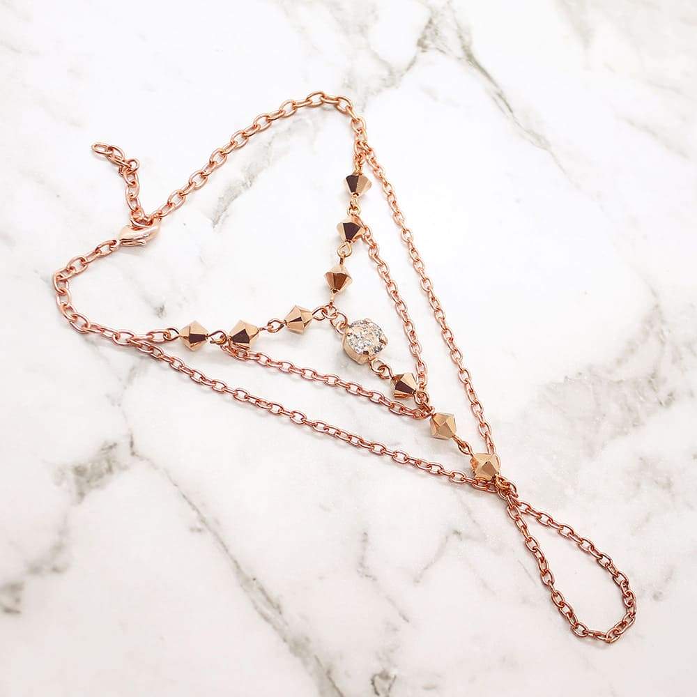 Rose gold Ryda bohemian hand chain on grey