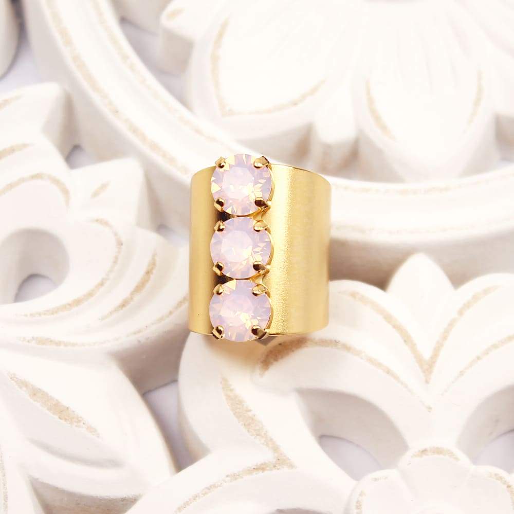 Simone three crystals statement ring Gold with Pink Opal on white floral plate.